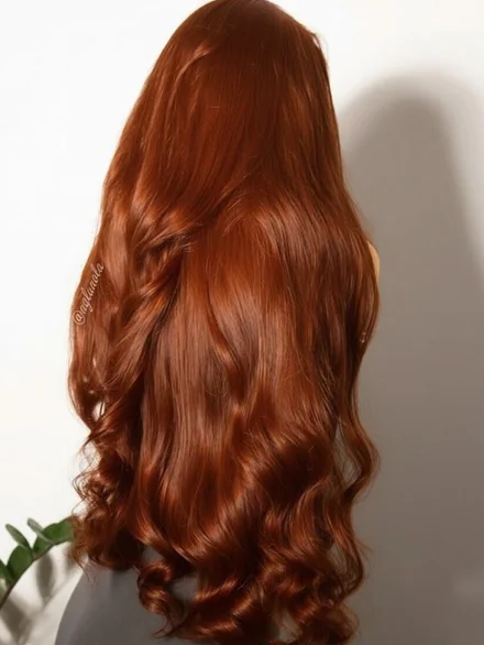 Coloración cobriza intensa en cabello largo con ondas suaves en las puntas, vista de espaldas
